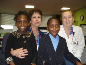 Carol Mulumba (left) thanks RNs Gloria Muniz and Star Ross for caring for her after her bone marrow transplant a year ago. Her 6-year-old brother Mark, second from the right, donated his bone marrow to help cure his sister of sickle cell anemia.